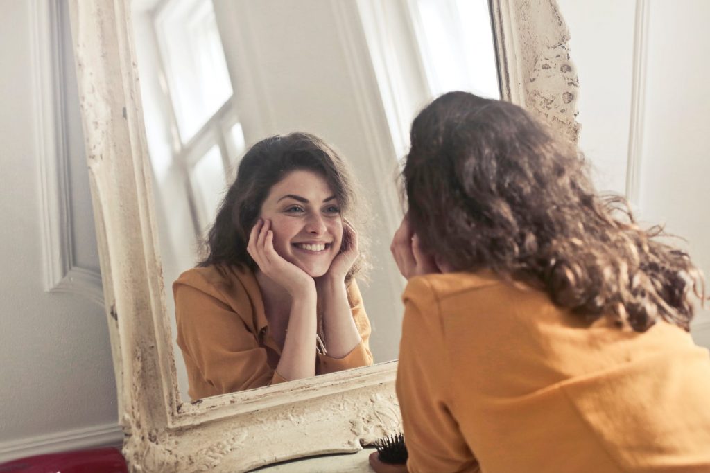happy woman looking in the mirror
